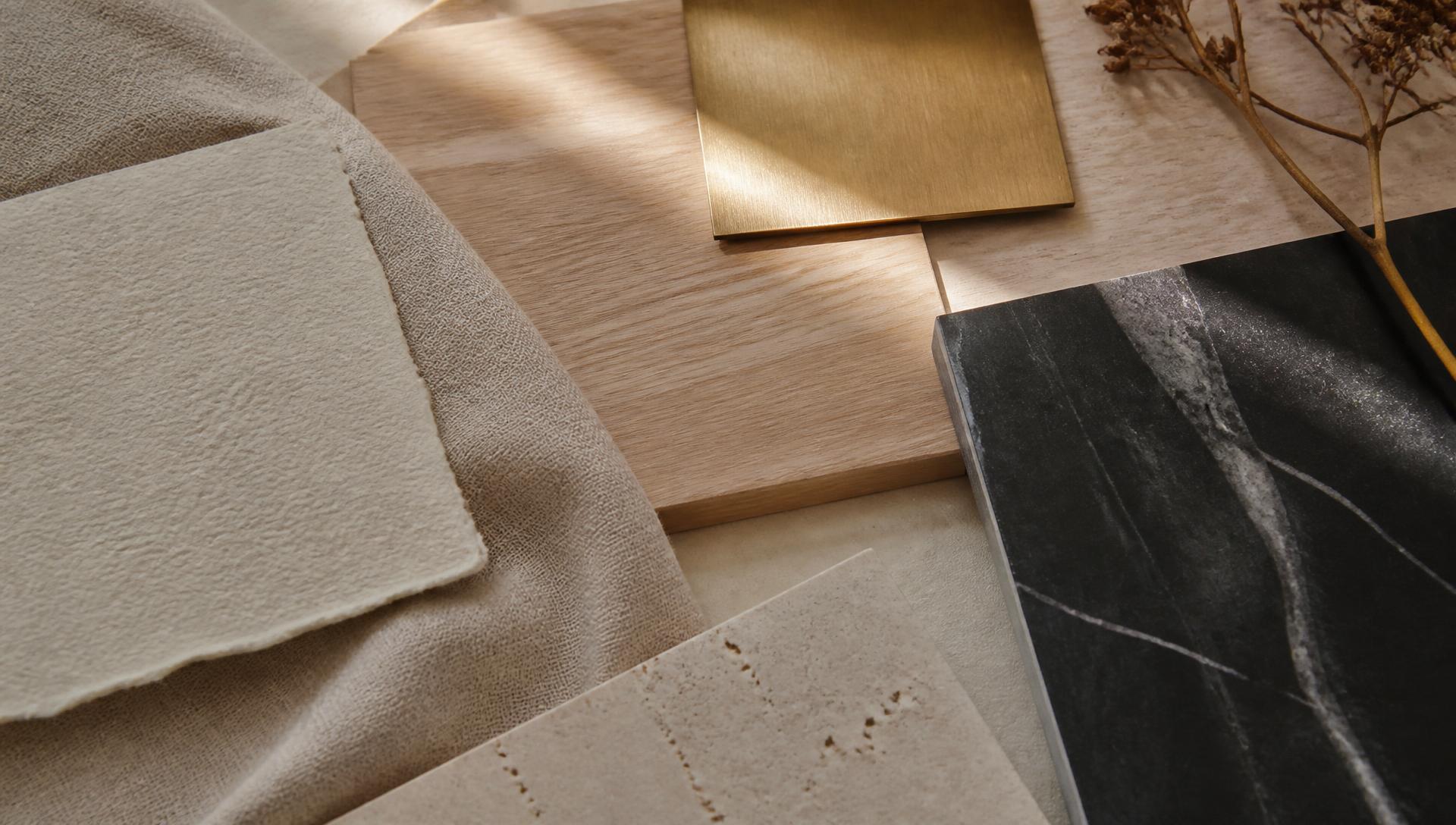 Gros plan d'un moodboard : échantillons de bois, pierre, laiton, papier texturé et tissu sous lumière naturelle